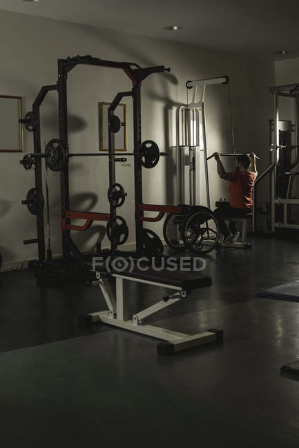 Handicapped man working out lat pulldown training at gym — Stock Photo