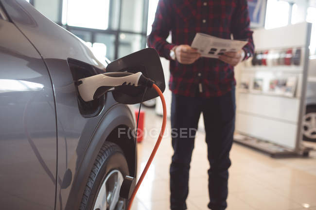 Fuel being filled in car tank at showroom — Stock Photo