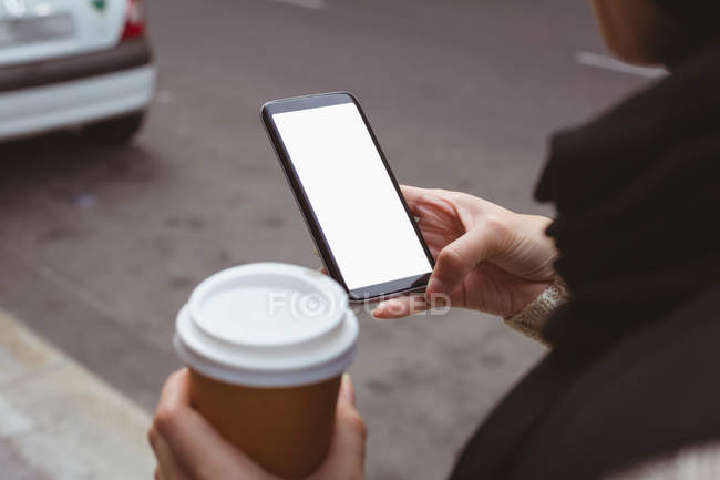 Mid section of hijab woman using mobile phone while holding coffee cup — Stock Photo