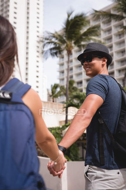 Couple romantique tenant la main sur le trottoir de la ville — Photo de stock