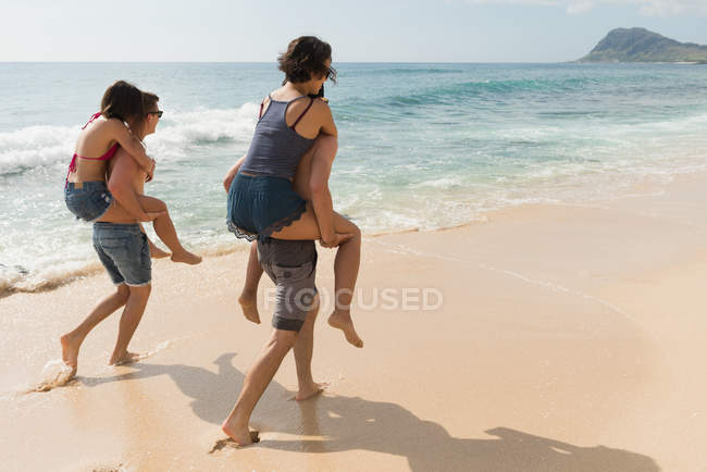 Two couples having fun in the beach on a sunny day — Stock Photo