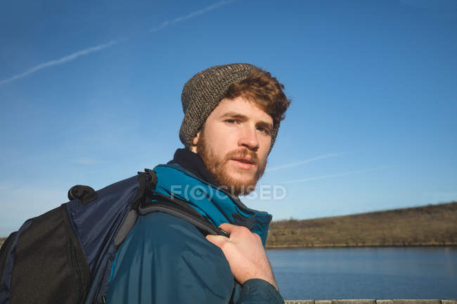 Портрет чоловіка-хокеїста, що стоїть з рюкзаком у сільській місцевості — стокове фото
