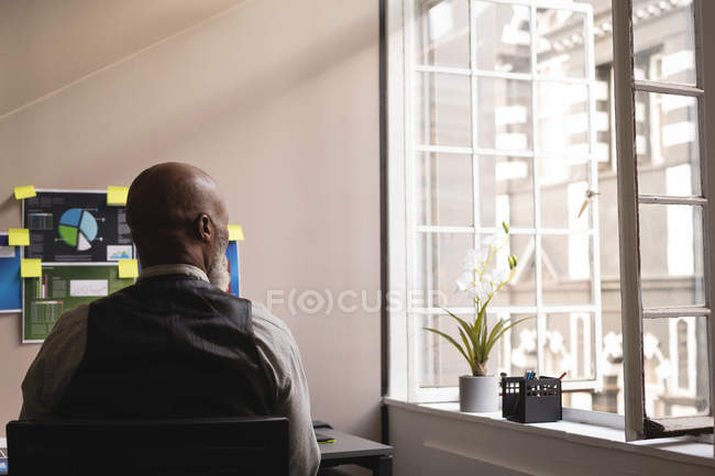 Thoughtful senior graphic designer relaxing in office — Stock Photo