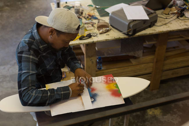 Mann bastelt Skateboard in Werkstatt — Stockfoto