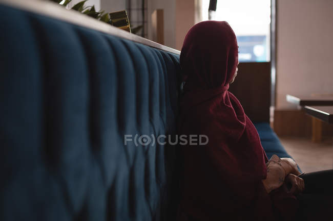 Femme d'affaires réfléchie dans le hijab se détendre à la cafétéria — Photo de stock