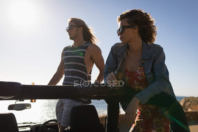 Couple standing together in the jeep on a sunny day — Stock Photo