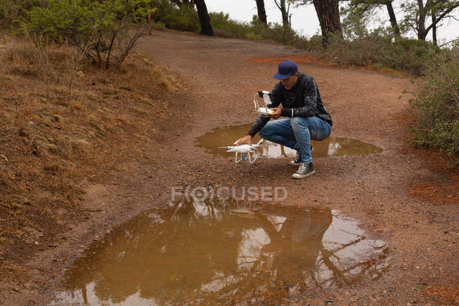Uomo che aziona un drone volante in campagna — Foto stock