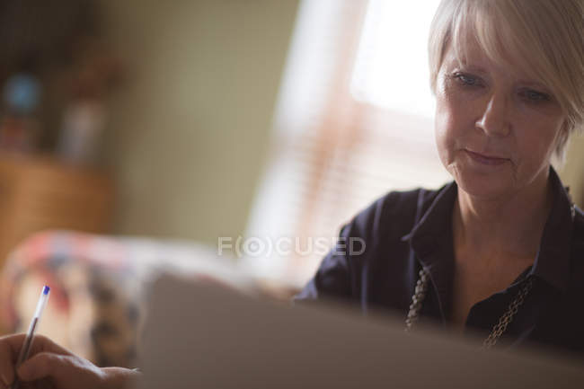 Close-up de mulher madura usando laptop em casa — Fotografia de Stock