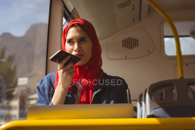 Hermosa mujer hijab hablando en el teléfono móvil en el autobús - foto de stock