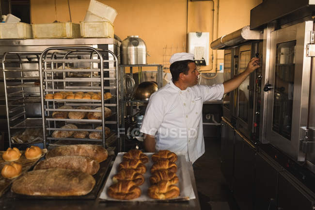 Reifer männlicher Bäcker arbeitet in Bäckerei — Stockfoto