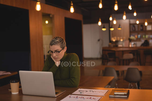 Бізнес-леді, використовуючи ноутбук в кафетерії в офісі — стокове фото