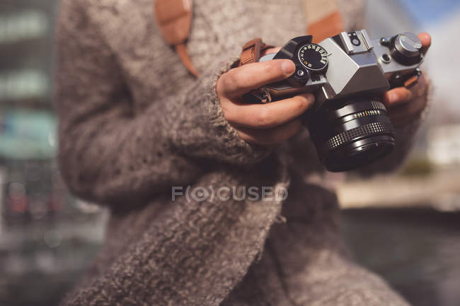 Жінка переглядає фотографії з цифровою камерою в місті — стокове фото