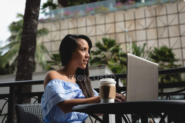 Smiling beautiful woman using laptop on cafe — Stock Photo