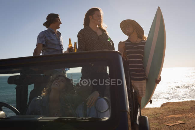 Grupo de amigos divirtiéndose en la playa en un día soleado - foto de stock