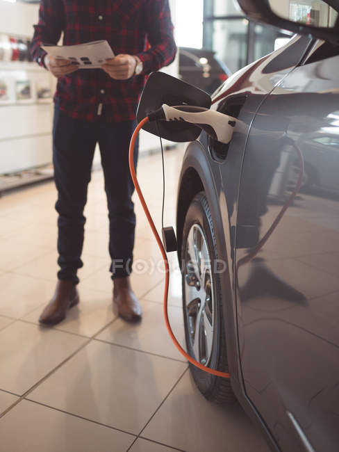 Fuel being filled in car tank at showroom — Stock Photo