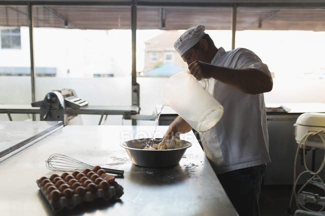 Maduro panadero macho preparando masa en panadería - foto de stock
