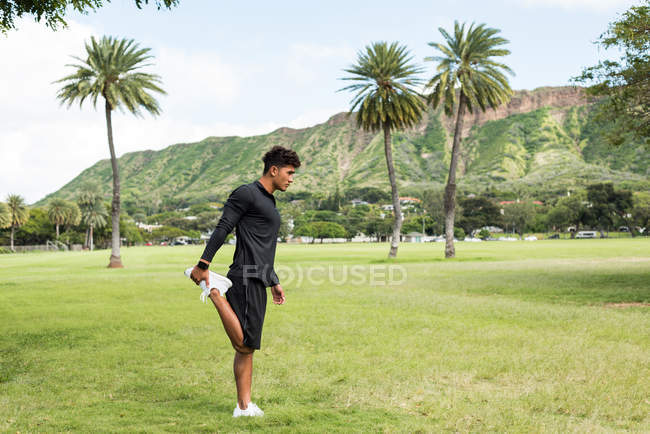 Jovem se exercitando no parque em um dia ensolarado — Fotografia de Stock
