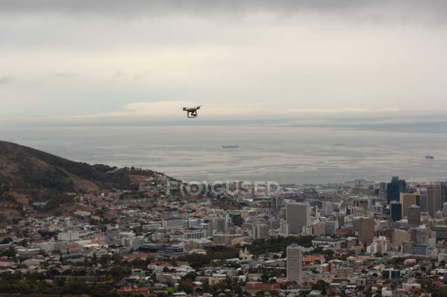 Drone flying in air over a cityscape — Stock Photo