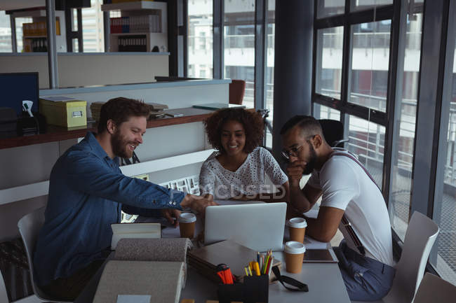 Architectes discutant sur ordinateur portable dans le bureau — Photo de stock
