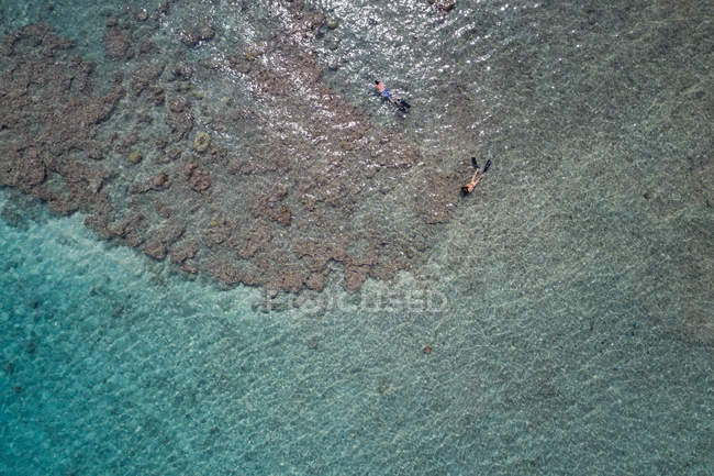 Vista aérea de pareja haciendo snorkel en mar turquesa - foto de stock