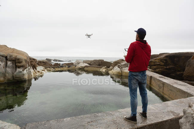 Людина, що керує літаючим безпілотником у сільській місцевості — стокове фото