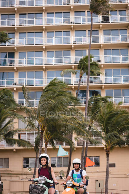 Casal feliz andar de scooter na cidade — Fotografia de Stock