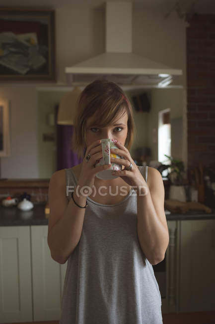 Портрет красивої жінки, що п'є каву вдома — стокове фото