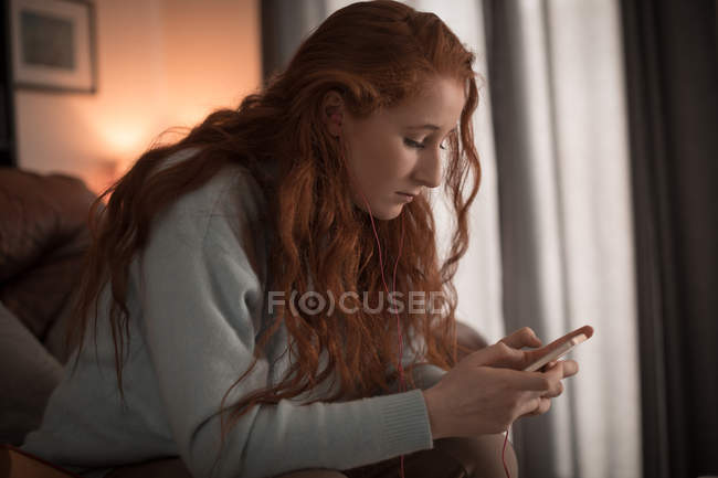 Schöne Frau mit Handy zu Hause — Stockfoto