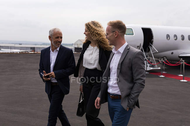 Business people walking at terminal on a sunny day — Stock Photo