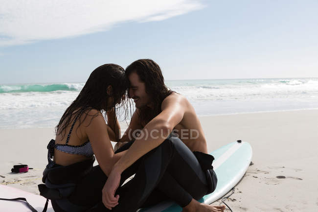 Surfer-Paar beim Romanzen am Strand an einem sonnigen Tag — Stockfoto
