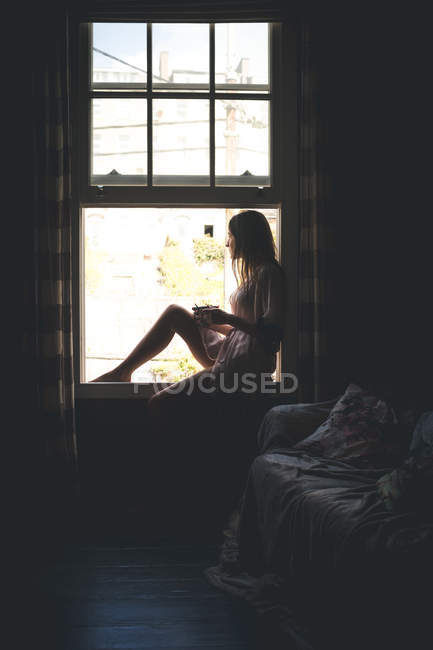 Nachdenkliche Frau mit Kaffee lieber Fenster zu Hause — Stockfoto