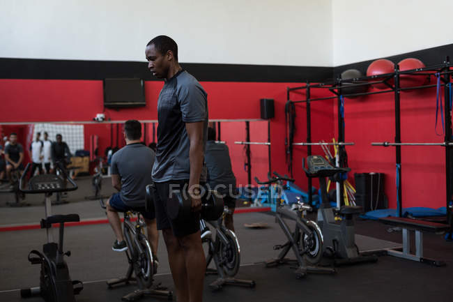 Exercice d'athlète avec haltères dans la salle de gym — Photo de stock