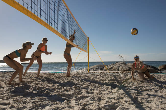 Joueuses de volley-ball jouant au volley sur la plage — Photo de stock