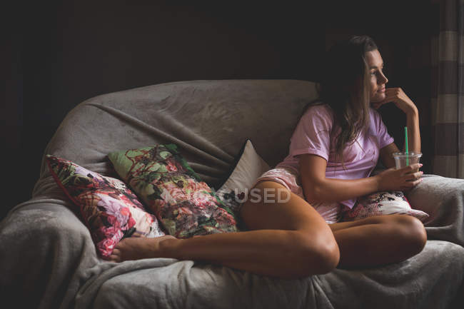 Nachdenkliche Frau entspannt sich im heimischen Wohnzimmer — Stockfoto