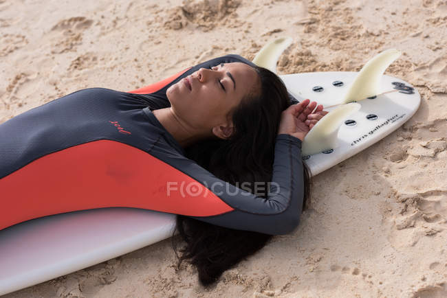 Жінка спить на дошці на пляжі в сонячний день — стокове фото