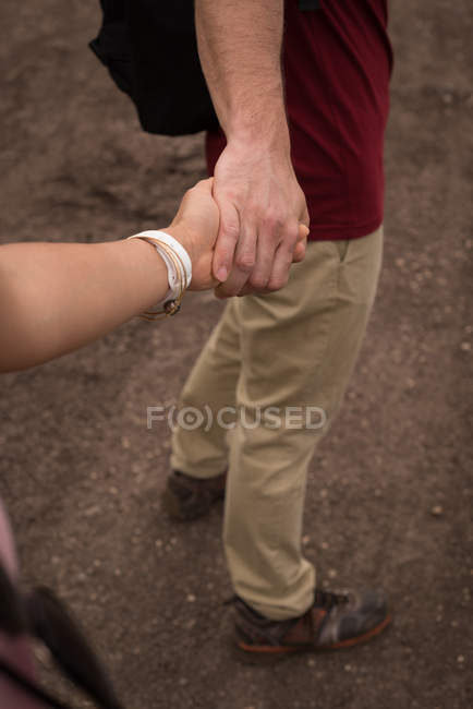 Casal romântico de mãos dadas no campo — Fotografia de Stock