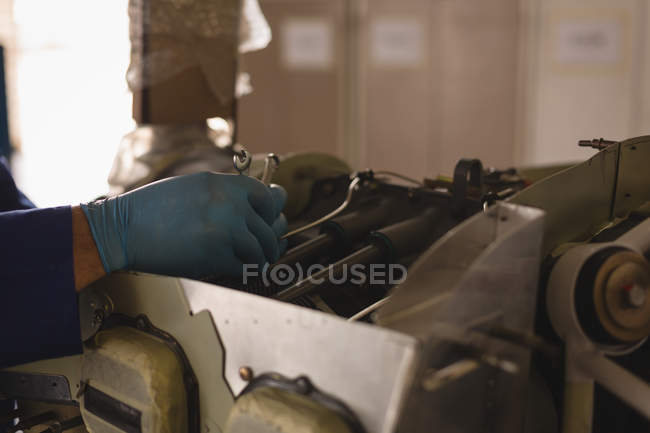 Primo piano dell'ingegnere che ripara il motore dell'aeromobile nell'hangar — Foto stock