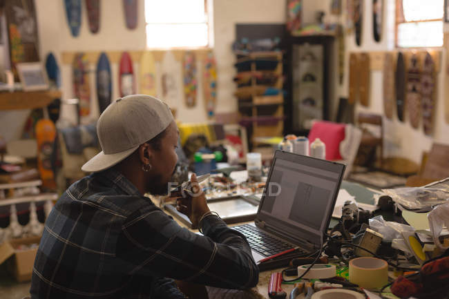 Homme attentif utilisant un ordinateur portable en atelier — Photo de stock