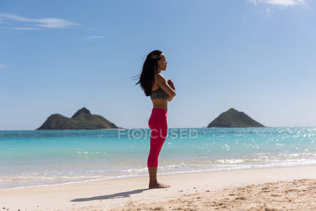 Frau macht an einem sonnigen Tag Yoga am Strand — Stockfoto
