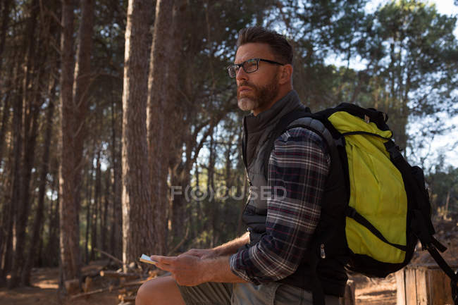 Thoughtful man standing with backpack standing in — Stock Photo