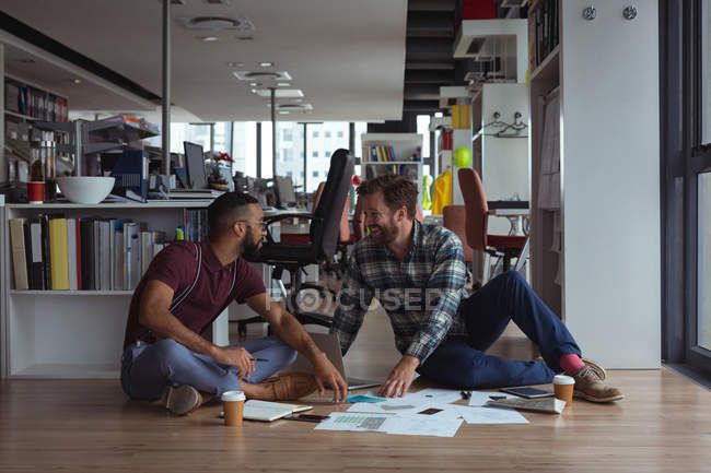 Архітектори взаємодіють один з одним на підлозі в офісі — стокове фото