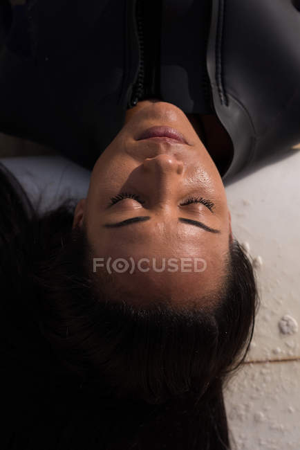 Close-yup of woman sleeping with surfboard in the beach — Stock Photo