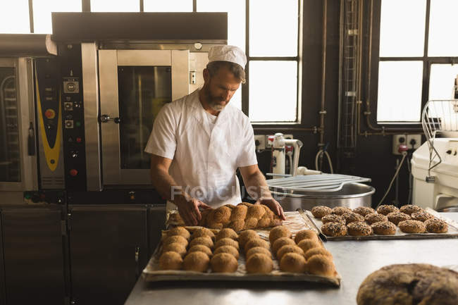 Maschio panettiere organizzare dolci da forno in panetteria — Foto stock