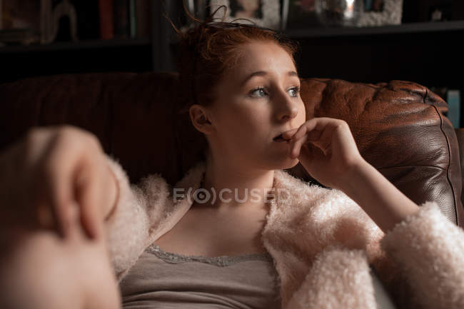 Nachdenkliche Frau entspannt sich im heimischen Wohnzimmer — Stockfoto