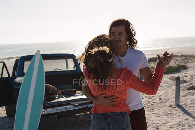 Paar tanzt an einem sonnigen Tag gemeinsam am Strand — Stockfoto