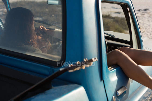 Pareja relajándose en una camioneta en la playa en un día soleado - foto de stock