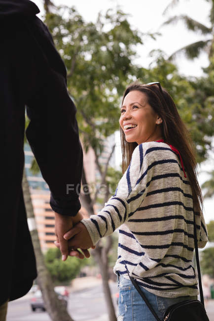 Romantic couple holding hands on sidewalk in the city — Stock Photo