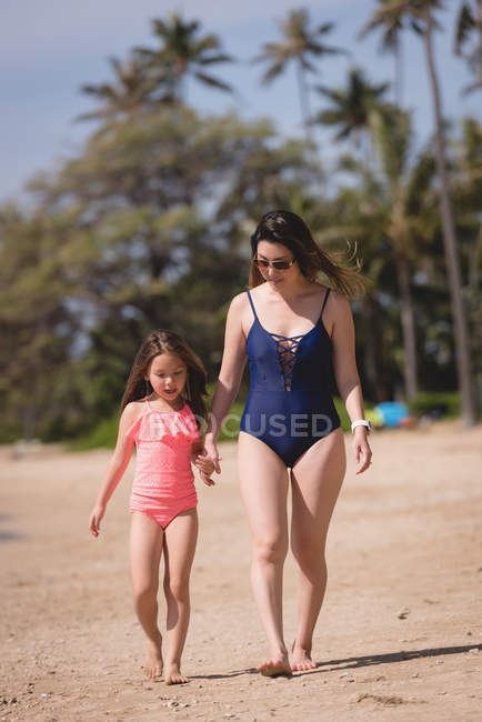 Mutter und Tochter spazieren an einem sonnigen Tag gemeinsam am Strand — Stockfoto