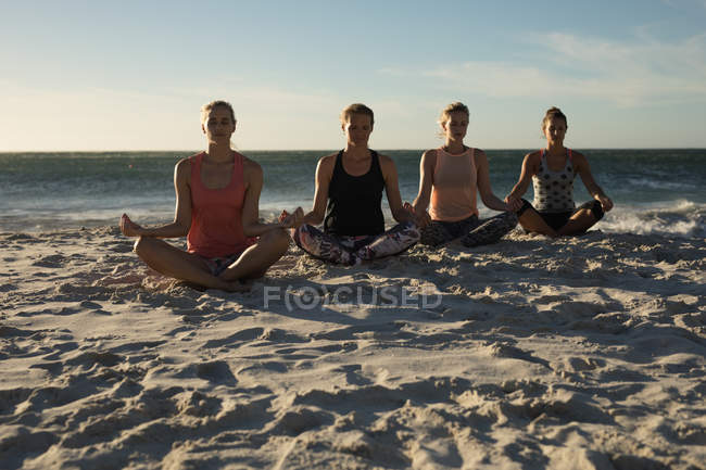 Жінки-волейболістки тренуються разом на пляжі — стокове фото