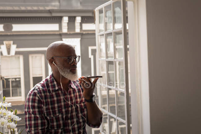 Старший графический дизайнер разговаривает по мобильному телефону в офисе — стоковое фото